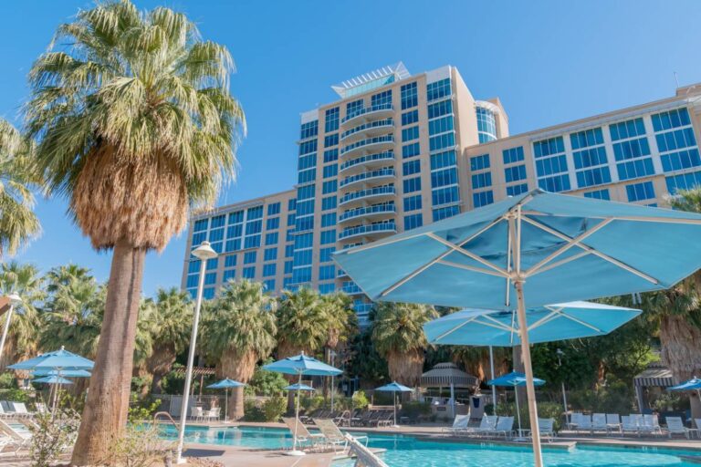 Picture of hotel exterior with pool and lounge chairs.